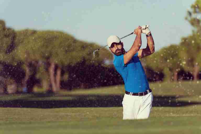 pro golfer hitting a sand bunker shot